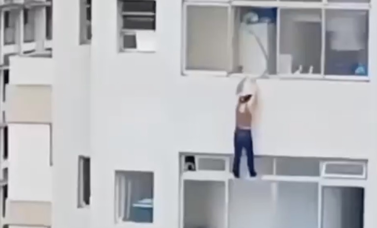 Mulher escorrega e fica pendurada para fora da janela no 15º andar de um prédio