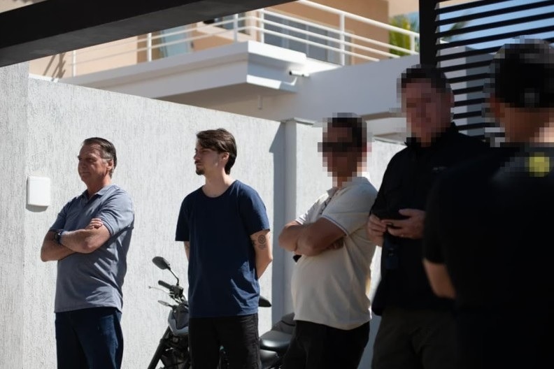 Vigiado por policiais, Bolsonaro aparece no jardim junto a Jair Renan