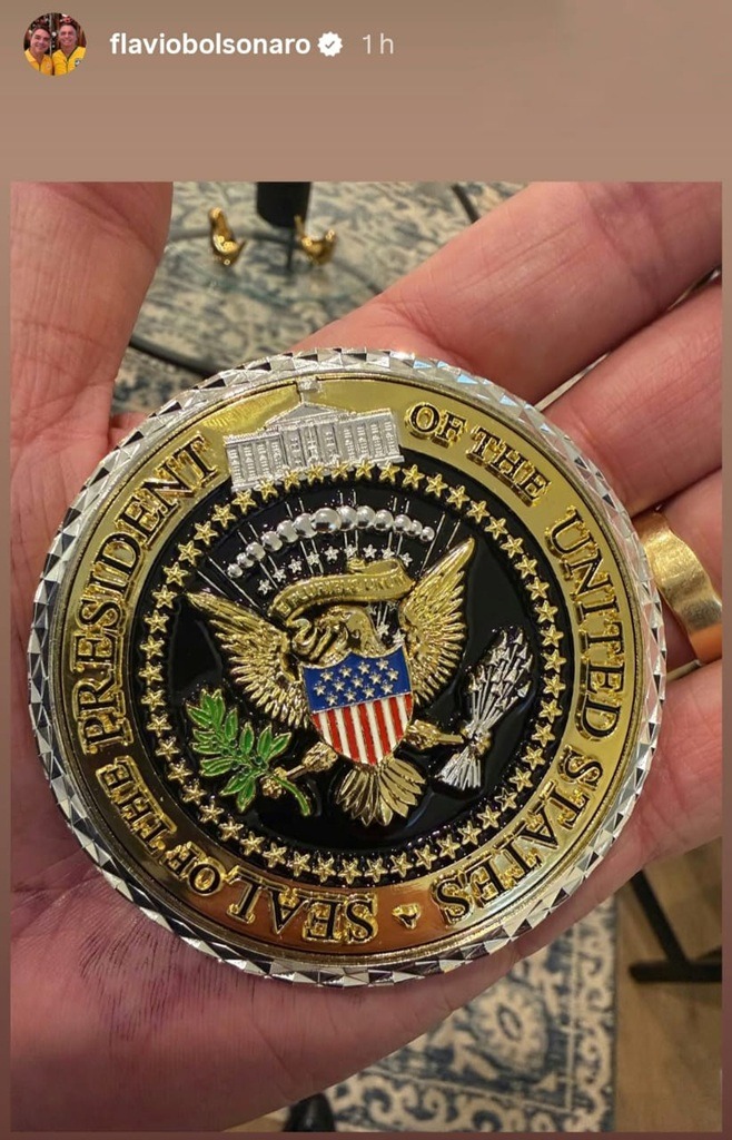 Flávio Bolsonaro exibe moeda de honra que ganhou de Trump