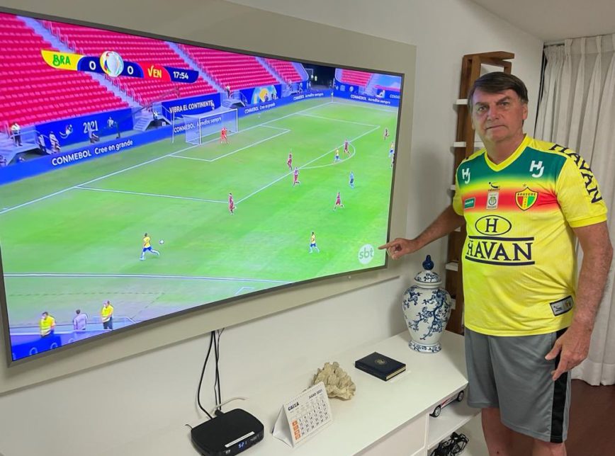 Bolsonaro provoca Globo e posta foto apontando para logo do SBT em jogo do Brasil