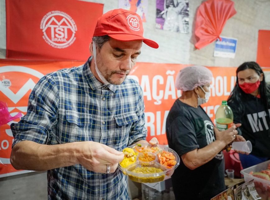 Wagner Moura come quentinha de camarão em ocupação do MTST e viraliza na web