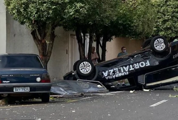 Caixão fica destruído após ser arremessado de carro funerário em batida