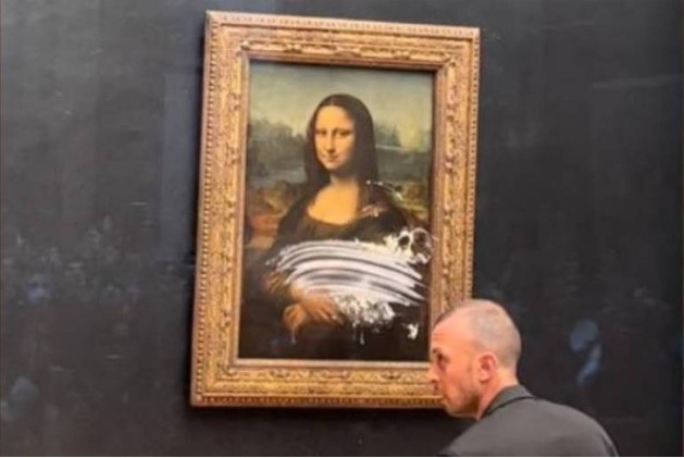 'Mona Lisa' é atacada com uma torta por visitante de peruca e cadeira de rodas