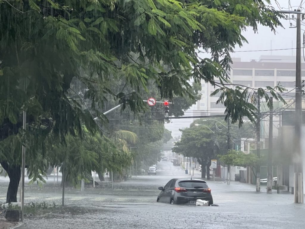 Carro fica boiando em lagoa formada em avenida de Natal