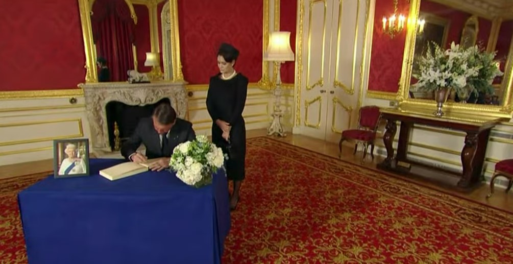 Ao lado de Michelle, Bolsonaro assina livro de condolências da rainha