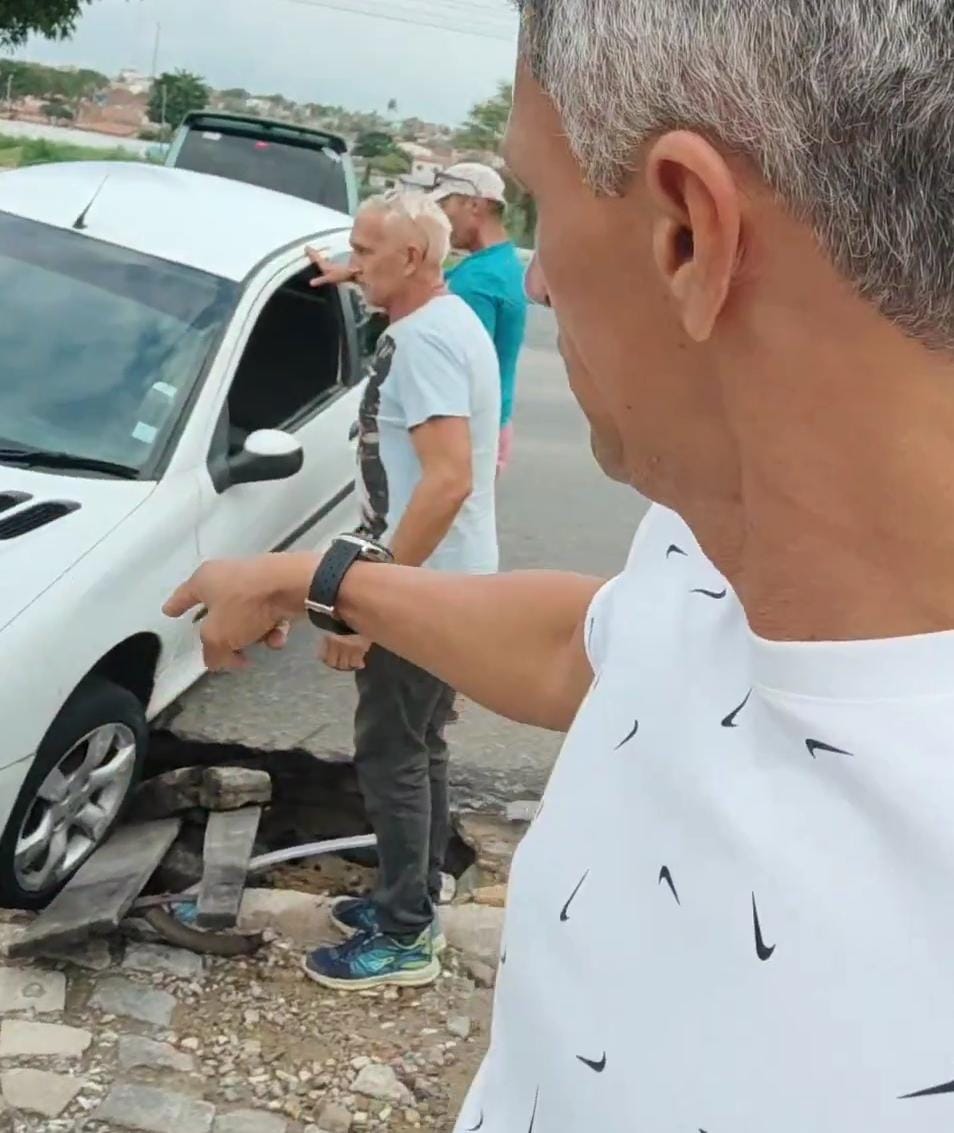 Carro cai em cratera, fica preso e é resgatado por moradores na avenida Itapetinga