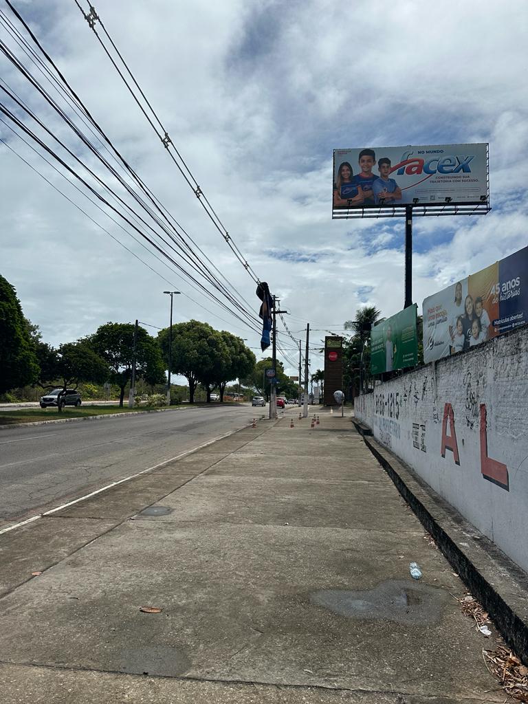 Painel de outdoor desprende e fica preso em fios de poste em Natal