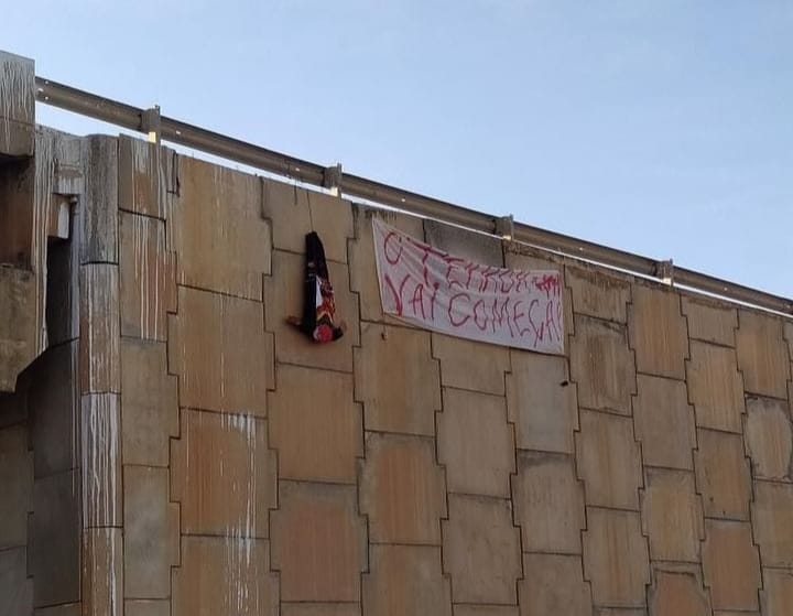Boneco de cabeça para baixo e faixa com mensagem de terror são colocados em viaduto em Mossoró